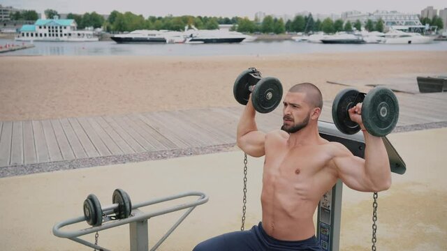 Saint Petersburg, Russia, Yuzhnaya Doroga street, August 21, 2020. Athletic man has a beautiful body, trains on the Playground in the summer on the street.