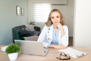 Pretty female doctor working from home