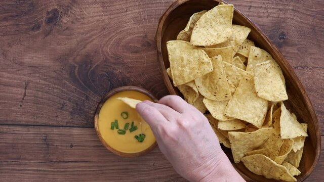 Eating a Tortilla Chips with Queso Cheese Dip