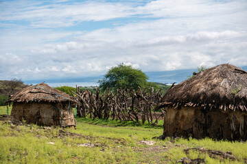 Fototapeta na wymiar Traditional Maasai Village with Clay Round Huts in Engare Sero area near Lake Natron and Ol Doinyo Lengai volcano in Tanzania, Africa
