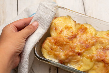 Scalloped potatoes with ham and cheese on white background