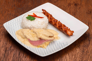 Healthy dish on a white plate consisting of rice, cheese, ham, chorizo and parsley