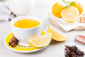 Cup of lemon tea with ginger. On a white wooden table