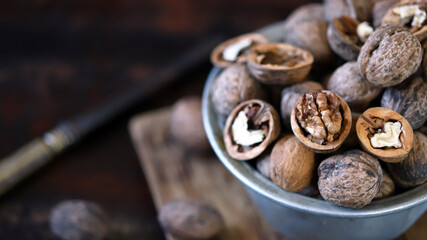 Walnuts in a bowl on a dark background.