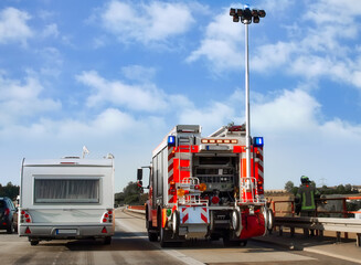 Fire truck with extended lighting mast on the highway in Germany. Securing an accident site