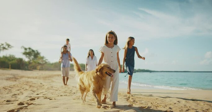 Happy young family walking on the beach with their dog, family lifestyle