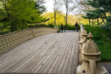 New York, NY / USA - April 26 2020: Empty Wooden Pedestrian Bridge with wrought iron Railings in the Central Park, New York.