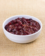 isolated Black beans on white plate on raw cotton dish towel. feijoada