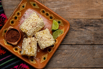 Fototapeta na wymiar Mexican corn on the cob also called elotes with cheese and mayonnaise on wooden background