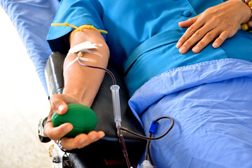 Blood donor at donation area with a green bouncy ball holding in hand.