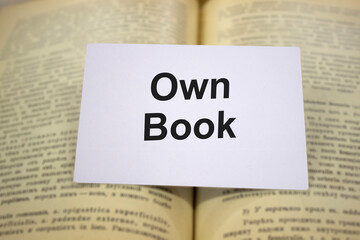 Own books written in white note on open books