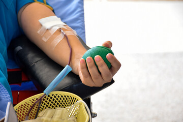 Blood donor at donation area with a green bouncy ball holding in hand.