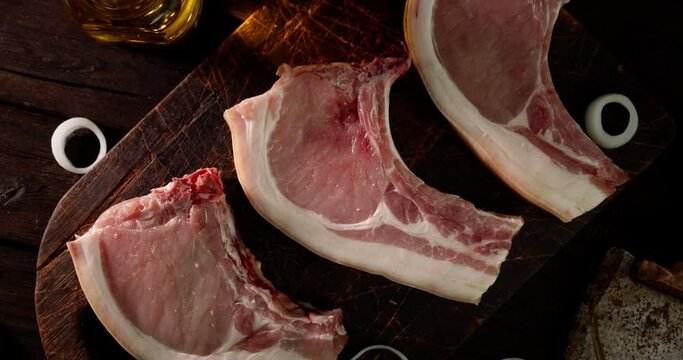 Raw pork escalope on the cutting board slowly rotate. 
