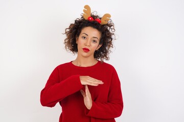 Young arab woman with curly hair wearing christmas headband on white background being upset showing...