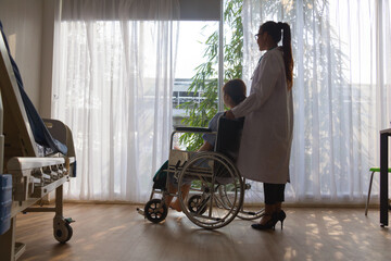 Doctor carrying woman patient on  Wheelchair. They are in hospital. disabled person,help. Photo concept depression and Patient.