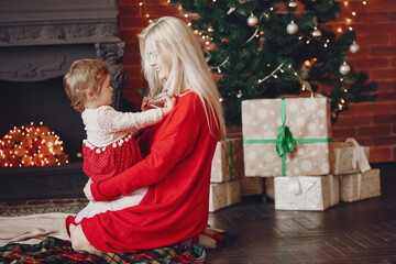 Beautiful mother in a red sweater. Family with cristmas gifts. Little girl near christmas tree