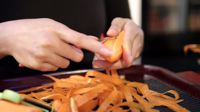 Woman chef carving carrot with a carving knife in Thailand