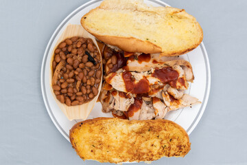 BBQ meal of sliced chicken, baked beans, and butter toasted bread will taste as delicious as it looks
