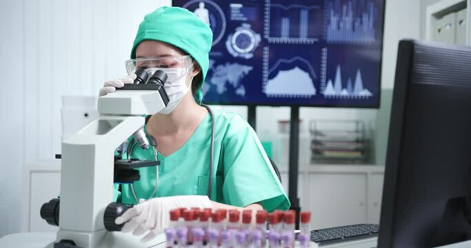 asian female doctor use microscope
