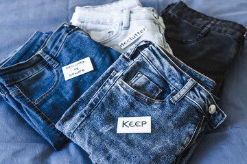 Keep vs Declutter label on different jeans in various denim colors, tidying up concept