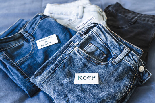 Keep vs Declutter label on different jeans in various denim colors, tidying up concept