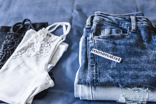 Minimalism label on set of two jeans and two tops in different colors, tidying up concept