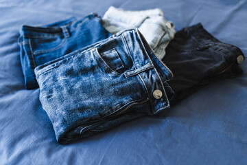organizing your wardrobe, different jeans in various denim colors getting sorted out