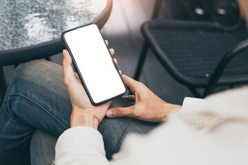 cell phone mockup blank white screen.woman hand holding texting using mobile on desk at coffee shop.background empty space for advertise.work people contact marketing business,technology
