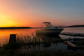 Boat At Sunset Docked Alongside A Pier