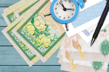 10 Sri Lankan rupees bills and alarm clock with pen and envelopes. Tax season concept, payment deadline for credit or loan. Financial operations using postal service