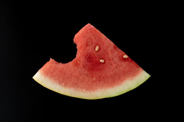 sliced watermelon fruit sitting on a black background