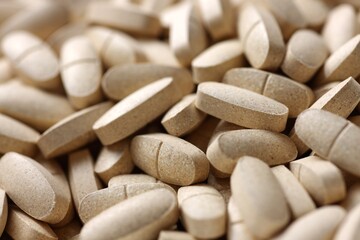 Fototapeta na wymiar Daily vitamins on the white background. Light brown pills isolated on white. Multivitamins.