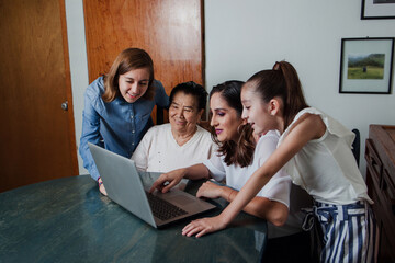 Latin Sisters using a computer with mother and grandmother Mexican family in Mexico