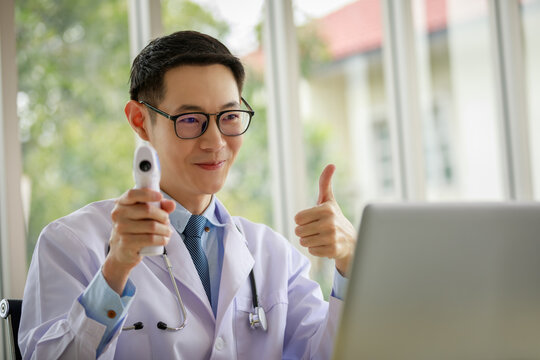 Doctor Explains How To Use It A Body Thermometer For The Patient On Laptop Computer