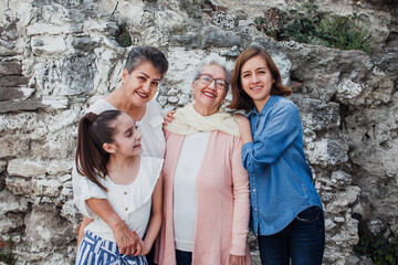 Three generations of latin women outside family home, mexican grandmothers and granddaughters in Mexico