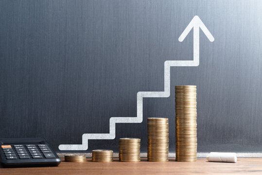 Financial growth and investment progress. Stack of coins and calculator. Steps and arrow drawn on blackboard.