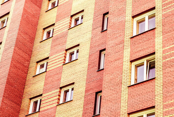 The facade of a new multi-storey residential building is built of brick.  Residential apartment...