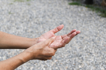 Closeup hand of person massage her hand from pain in healthy concept on nature background.