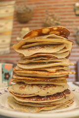 stack of pancakes on a plate. Homemade sugary pancakes with cozy blurry background. Pile of hotcakes