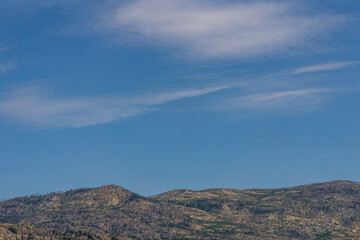 Sky with white clouds above small mountains in okanagan valley Canada.