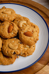 homemade almond cookies in ceramic white plate on wood table background.