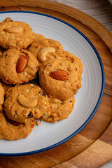homemade almond cookies in ceramic white plate on wood table background.