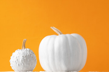 halloween background of pumpkin painted white in orange background