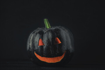 halloween background of black painted pumpkin on black background