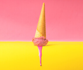 melted pink strawberry ice cream on yellow color background