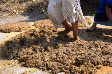 feet of a woman while trampling the soil to build a wall