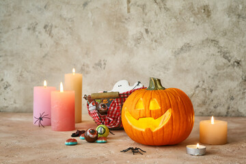 Carved Halloween pumpkin, sweets and candles on table