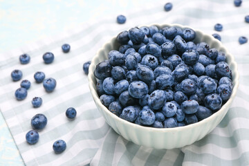 Bowl with tasty ripe blueberry on table