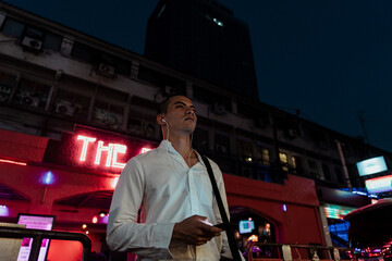Obraz premium Business man listen to music with earphone at night.