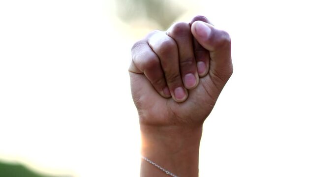Black hand raised fist in air in political protest, close-up clench fist